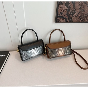 Detail view of stylish crocodile pattern handbags with metallic texture and gold hardware