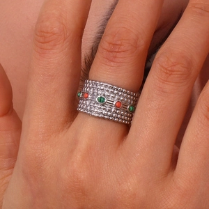 Detailed close-up of bohemian silver beaded ring with vibrant red and green natural stones