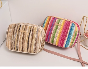 Detailed view of woven rainbow pattern texture and golden metal logo on shoulder bag