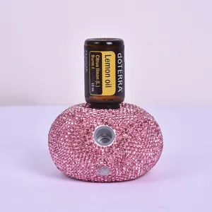 Detail of pink rhinestone essential oil diffuser with a dōTERRA lemon oil bottle on top