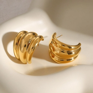 Detailed view of chunky multi-layered gold C-shaped earrings with polished finish