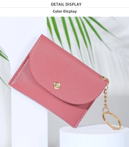 Detail of rose pink PU leather wallet with golden button closure and keychain chain