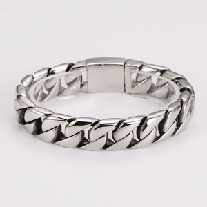 Detail of chunky silver stainless steel Cuban link bracelet with secure square clasp