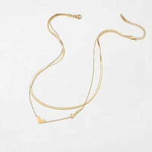 Détail du collier double rang doré avec chaîne serpent, pendentif cœur et mot Love