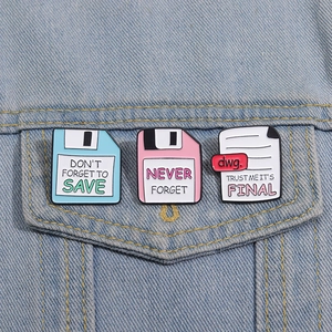 Dettaglio di spille in smalto a forma di floppy disk retrò su una tasca di jeans
