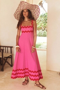 Detail of rose pink maxi dress with red wave patterns and natural cotton linen texture