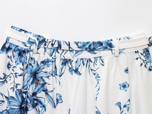Gros plan du motif floral bleu sur tissu mousseline blanc avec passants de ceinture