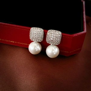 Square zircon and round pearl drop earrings on a luxury red velvet jewelry gift box