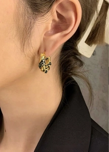 Detail of vintage 18K gold stainless steel hoop earring with black spotted leopard pattern
