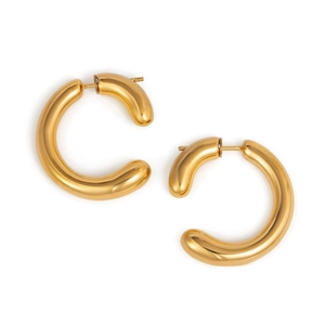 Détail macro de grosses boucles d'oreilles créoles en forme de C plaquées or 18 carats