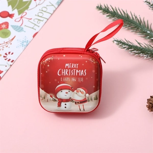 Close-up of red tinplate Christmas coin purse with Santa and snowman on pink background