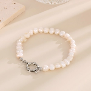 Détail d'un bracelet en perles blanches naturelles avec un fermoir à bascule argenté