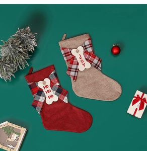 Detail of red and khaki linen Christmas stockings with festive bows and wood tags
