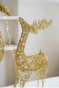 Detailed close-up of golden glittered wire reindeer Christmas ornament with warm lights
