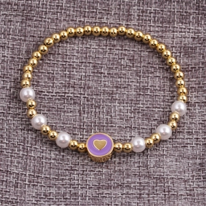 Detailed close-up of beaded bracelet with gold beads, pearls and purple heart charm