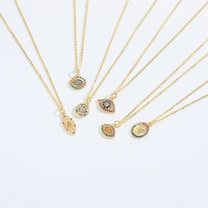 Detailed macro view of six gold evil eye necklaces with colorful zircon stones and charms