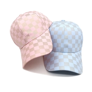 Detail of plaid baseball caps in pink gold and light blue silver with metallic finish