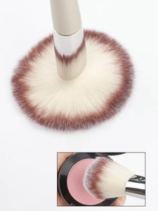 Macro view of champagne powder brush showing soft bristles picking up pink blush
