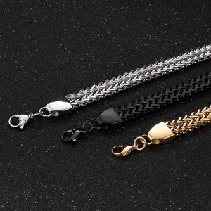 Close-up of titanium steel Spiga wheat chain bracelets in silver, black, and gold colors