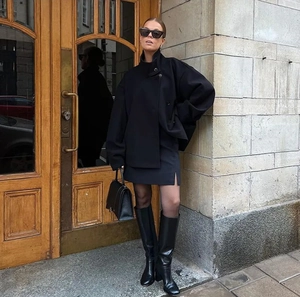 Détail d'un manteau court élégant en laine noire avec col montant et boutonnage simple