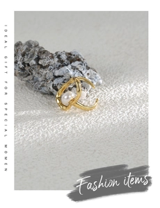 Close-up of a gold irregular pearl ring displayed on a natural rock decorative element