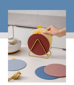 Detail of round silicone heat-resistant mats organized on a gold metal storage rack