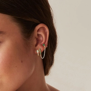 Detailed view of layered gold snake earring and green zircon hoop with elegant tassel chain
