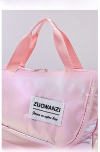 Detail of reinforced woven handles and logo patch on pearlescent pink waterproof bag