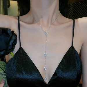 Detail of silver Y-shaped tassel necklace featuring brilliant cubic zirconia on model
