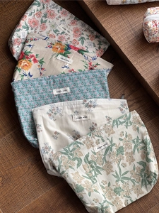 Detail von fünf floralen Baumwolltaschen mit 'simple wish'-Label auf einer Holzoberfläche