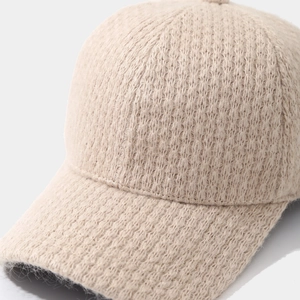 Gros plan de la casquette de baseball tricotée beige montrant la texture de laine