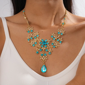Detail of vintage hollow flower necklace with water drop zircon and blue gemstone