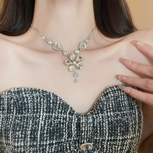 Detailed view of luxury flower pendant necklace with clear rhinestones on model neck