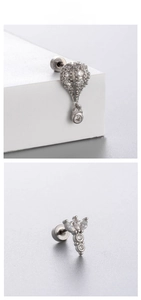 Close-up of silver screw-back earrings with balloon and floral patterns in white zircon