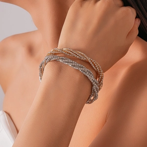 Detail of multi-layer crossover wrap bracelet with sparkling rhinestones in gold and silver