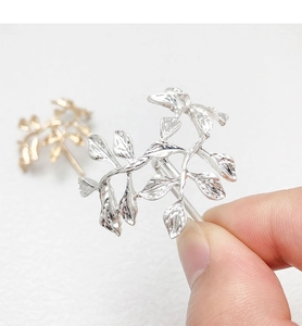 Detail shot of elegant leaf hair hook in metallic silver and gold finishes