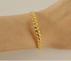 Detailed shot of golden circular disk link bracelet featuring a minimalist geometric design