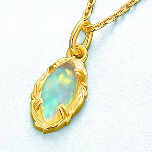 Macro shot of marquise-cut opal pendant with gold leaf texture and chain on blue background