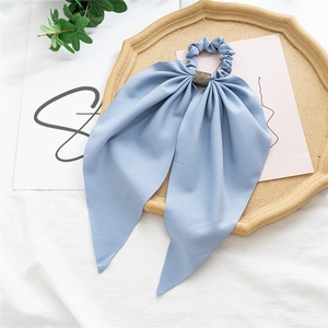 Blue fabric scrunchie with sparkling rhinestone center on a rustic wooden tray decoration