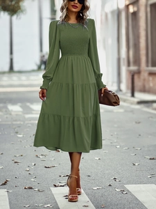 Détail de la robe midi vert armée à manches longues avec buste froncé et jupe évasée