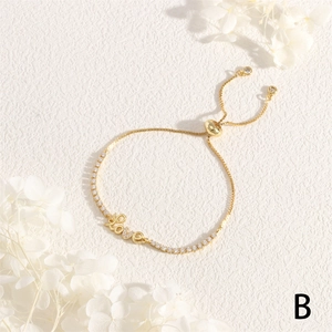 Detailed shot of golden LOVE letter bracelet with cubic zirconia and adjustable pull chain