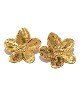 Detailed view of golden flower earrings with textured petals and brushed finish