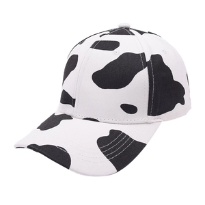 Classic cow print baseball cap with black and white spots and curved brim for women