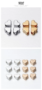 Macro detail of gold and silver heart-shaped metal spacer beads for DIY jewelry making