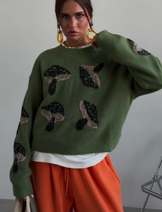 Detail of green crew neck knit sweater featuring pink and black mushroom pattern jacquard
