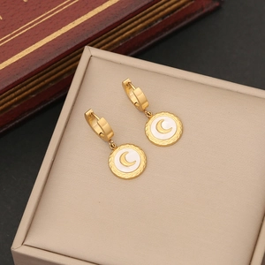 Elegant gold crescent moon hoop earrings with white inlay on a vintage display