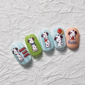 Macro shot of 3D cartoon dalmatian nail art stickers on a white textured background