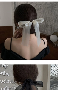 Back view of a model wearing large black and white organza bow hair clips for elegant styling