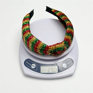 Christmas headband with red, green, and gold glitter stripes in a knotted festive design