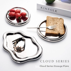 Flat lay of cloud-shaped and round mirror-polished stainless steel storage trays